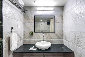 Baño blanco con lavabo y espejo en Krushnai Resort, en Lonavala