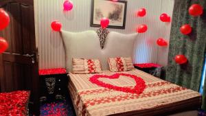 a bedroom with a bed with a heart on it at Rashk e Qamar in Murree