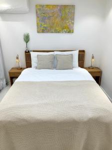 a bedroom with a large white bed with two tables at Comma 2, Cozy Semi-basement in Seoul