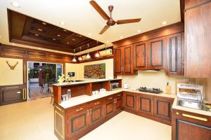 a kitchen with wooden cabinets and a ceiling fan at Group Getaway Patong House in Patong Beach
