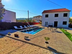 a backyard with a swimming pool and a house at Holiday Home Nino with private pool in Slatine