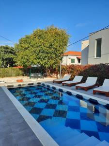 einen Pool mit Liegestühlen neben einem Gebäude in der Unterkunft Holiday Home Nino with private pool in Slatine