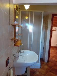 La salle de bains est pourvue d'un lavabo blanc et d'une douche. dans l'établissement La Plumeria, à Noto