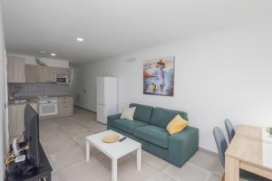 una sala de estar con un sofá y una mesa en Lightbooking Apartamento con terraza en playa de Arinaga, en Agüimes