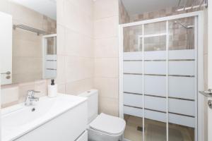 Un baño blanco con inodoro y ducha. en Lightbooking Apartamento con terraza en playa de Arinaga, en Agüimes 23 fotos más
