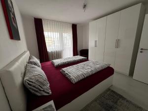 a small bedroom with two beds and a window at Best Apartment Augsburg in Augsburg