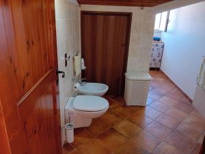 La salle de bains est pourvue de toilettes et d'un lavabo. dans l'établissement La Plumeria, à Noto