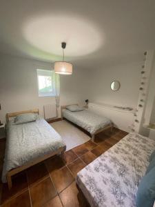 1 dormitorio con 2 camas y ventana en GÎTE GUIROYA, en Saint-Jean-le-Vieux