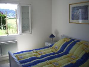 a bedroom with a bed with a blue and yellow blanket at l'escapade in Saint-Étienne-lès-Remiremont