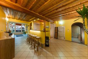 uma cozinha com paredes amarelas e bancos de bar em Le Domaine du Verger gîtes et SPA em Osenbach