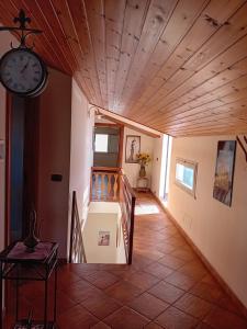 un couloir avec une horloge et des escaliers dans une maison dans l'établissement La Plumeria, à Noto