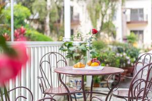 una mesa con un jarrón de flores y fruta. en Villa Hoa Ly Đà Lạt en Dalat