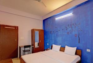 Cette chambre dispose d'un lit avec un mur bleu. dans l'établissement Hotel Sambodhi Palace, à Bhopal