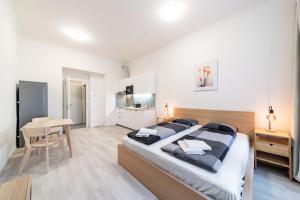 a bedroom with a large bed and a table at Apartments Borivojova 63 in Prague