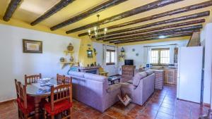 ein Wohnzimmer mit Sofas und einem Tisch sowie eine Küche in der Unterkunft Cortijo Molino Benizalte Orgiva by Ruralidays in Órgiva