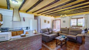 a living room with two couches and a kitchen at Cortijo Molino Benizalte Orgiva by Ruralidays in Órgiva