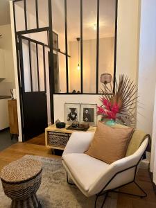a living room with a white couch and a table at Appartement Cosy Paris Montmartre in Paris