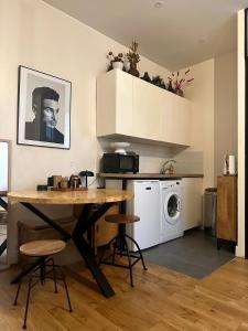 a kitchen with a table and a washing machine at Appartement Cosy Paris Montmartre in Paris