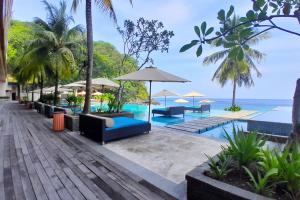ein Resort mit einem Pool, Tischen und Sonnenschirmen in der Unterkunft Paradise Island 1 BR Beach View NE33 in Teluk Nara
