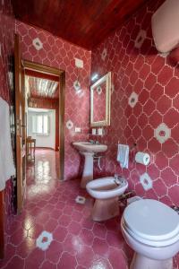 ein rosafarbenes Bad mit einem WC und einem Waschbecken in der Unterkunft La torretta sul cortile in Monteroduni
