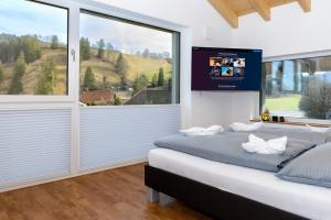 a bedroom with a bed with a tv on the wall at Berg Fux - Ferienwohnung Alfred der Büffel in Sonthofen
