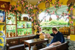 dos hombres sentados en una mesa en un bar haciendo un jarrón en Cali Hill Resort en Phu Quoc