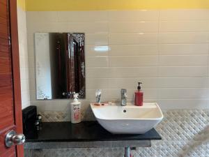 a bathroom with a white sink and a mirror at Cali Hill Resort in Phu Quoc