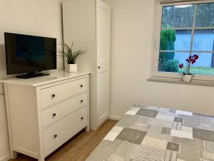 ein Schlafzimmer mit einer Kommode mit einem Fernseher drauf in der Unterkunft Ferienhaus Hete in Staphel