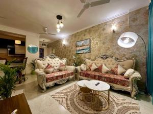 a living room with two couches and a table at Tranquil Manor With Swimming Pool in Lucknow