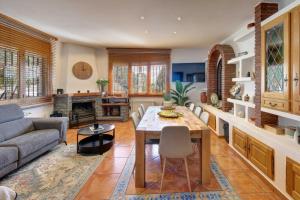 a living room with a table and a couch at VILLA ARBUCIES with private pool in Lloret de Mar
