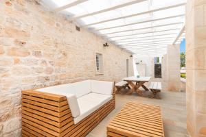 a living room with a white couch and a brick wall at Donna Vincenza in Selva di Fasano +59 photos