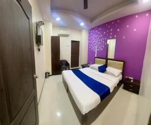 um quarto com uma cama com uma parede roxa em Hotel Zee Residency by SAN Hospitality em Mumbai