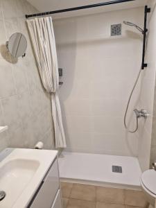 a white bathroom with a tub and a sink at Acogedor apartamento en l'Estartit con piscina y Parking in L'Estartit