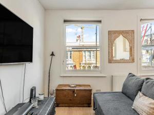 a living room with a couch and a flat screen tv at Pass the Keys Charming Victorian Gem Near Portobello Market - Explore Notting Hill in Style! in London