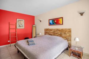 a bedroom with a bed and a red wall at Villa Le Saphir - Piscine chauffée et 3 chambres in Le Thoronet +17 photos