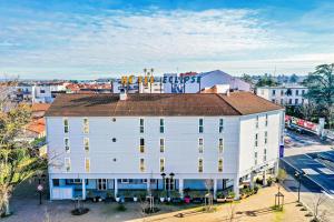 an overhead view of a white building with a sign on it at The Originals City, H&ocirc;tel &Eacute;clipse, Lyon Est in D&eacute;cines-Charpieu