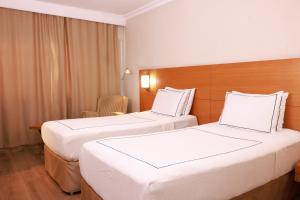 une chambre d'hôtel avec deux lits et une chaise dans l'établissement ANEMON KENT EGE, à Burunabat