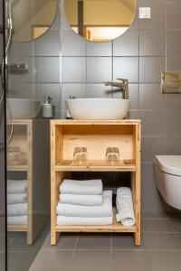 ein Badezimmer mit einem Waschbecken und einem Regal mit Handtüchern in der Unterkunft Hiša Erlah in Bohinj
