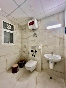 a bathroom with a toilet and a sink at Tranquil Manor With Swimming Pool in Lucknow