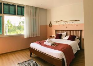 a bedroom with two beds and a window at CÁ CASA PhuQuoc in Phu Quoc
