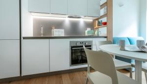 a kitchen with white cabinets and a table and chairs at Italianway - Cecchi 18 B in Milan