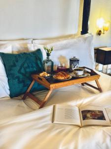 una bandeja de comida en una cama con un libro en Relais Conac 1888, en Castelnuovo Don Bosco