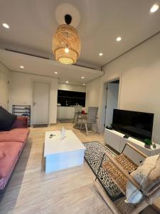 un soggiorno con divano e TV di The Oasis Luxury Apartment ad Aqaba