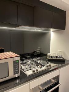 a kitchen with a stove and a microwave at The Oasis Luxury Apartment in Aqaba
