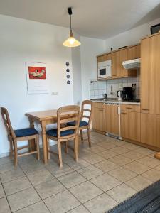 a kitchen with a wooden table and chairs and a table at Das Landhaus am Haff B10 in Stolpe