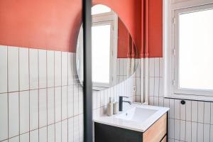 W łazience znajduje się umywalka i lustro. w obiekcie Apartment next to Palais des Congrès - Neuilly - II w mieście Neuilly-sur-Seine