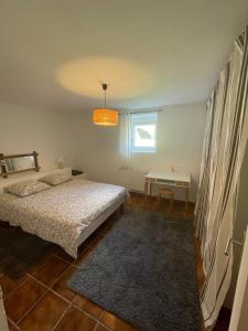 a bedroom with a bed and a table and a window at GÎTE GUIROYA in Saint-Jean-le-Vieux +14 photos