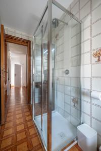 La salle de bains est pourvue d'une douche en verre et de parquet. dans l'établissement La torretta sul cortile, à Monteroduni