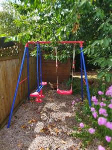 Saint-Étienne-lès-Remiremontにあるl'escapadeの柵の横の庭の二本のブランコ