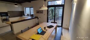een keuken met een houten tafel en een laptop erop bij De Wijngaard in Gent
